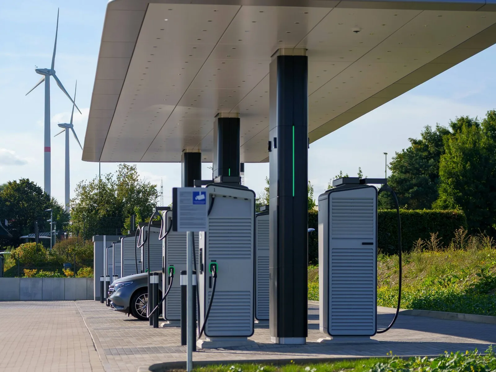 A row of DC fast EV chargers at a charging station