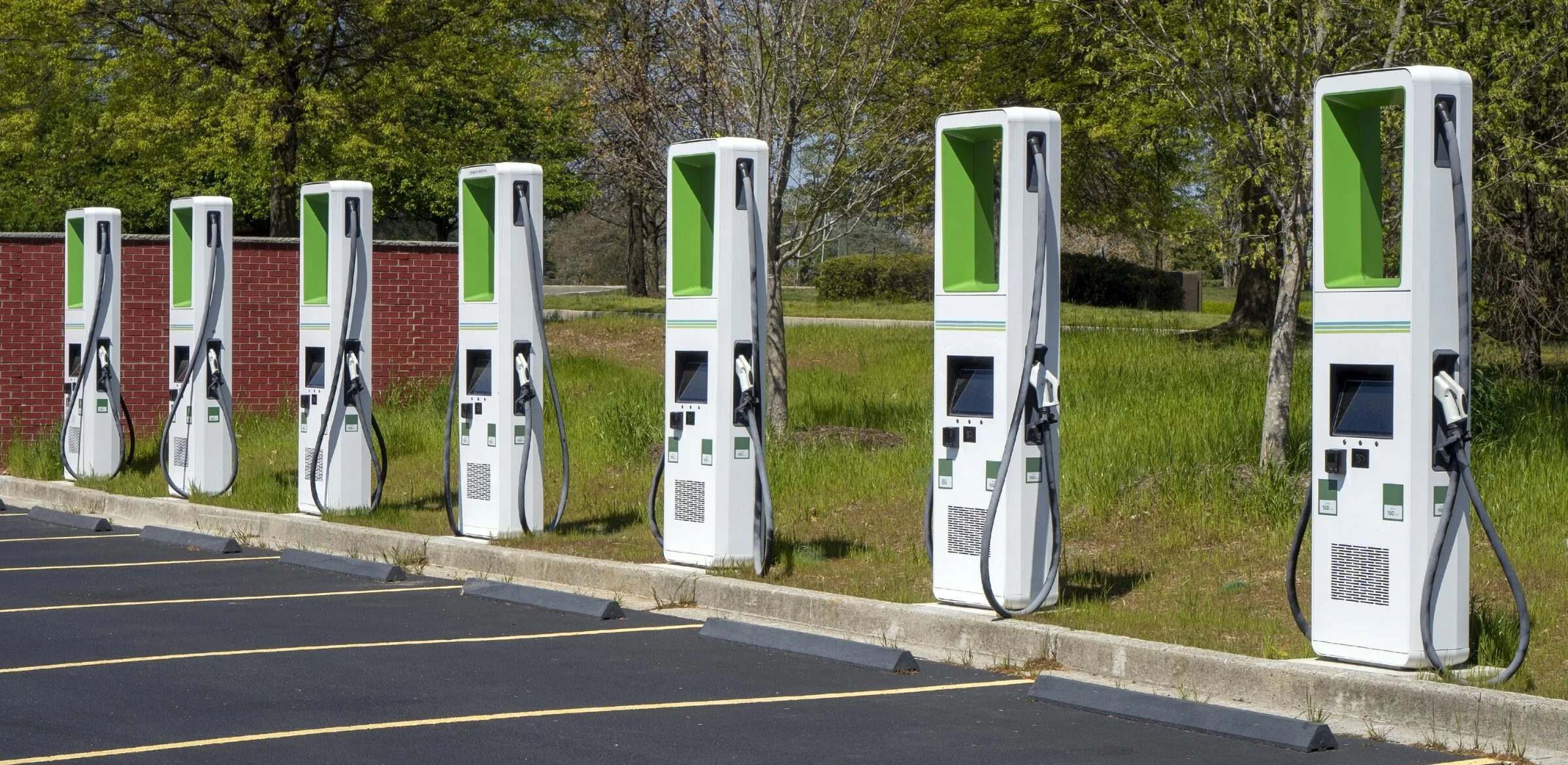 A row of DC fast chargers in a commercial parking lot